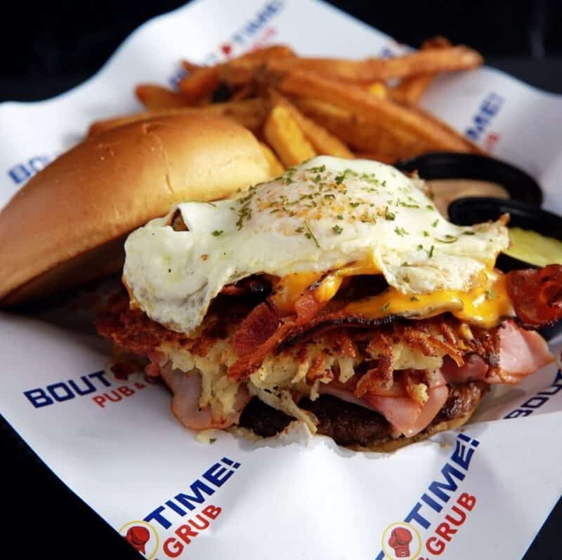 A ground chuck patty topped with sliced ham, corned beef hash, sliced bacon, a fried egg over medium and American cheese. Served on a burger bun with garlic mayo.