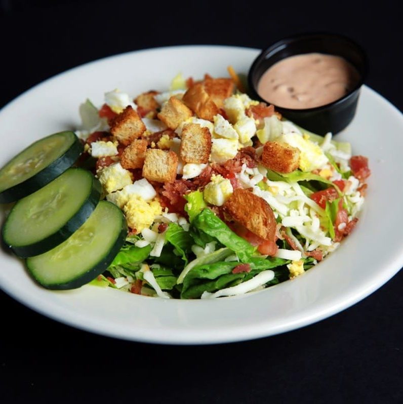 Salad Greens, cheese, eggs, tomatoes, apple wood smoked bacon, croutons and sliced cucumber. Dressing on the side.
